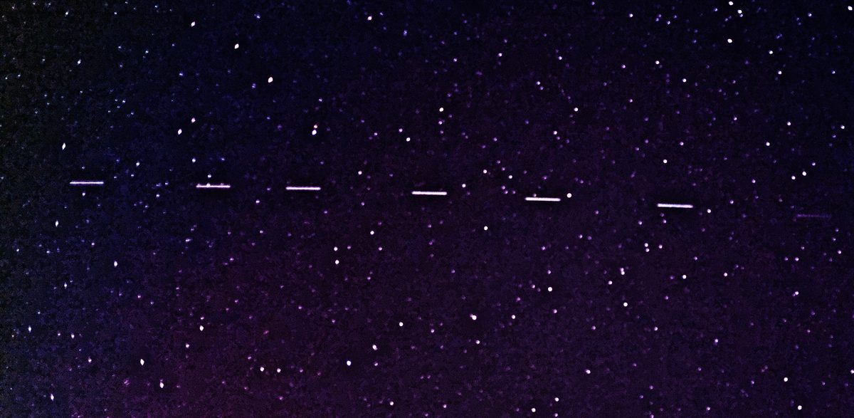 Sternenhimmel mit sechs kurzen hellen Strichen in einer Reihe, einer Starlink-Kette